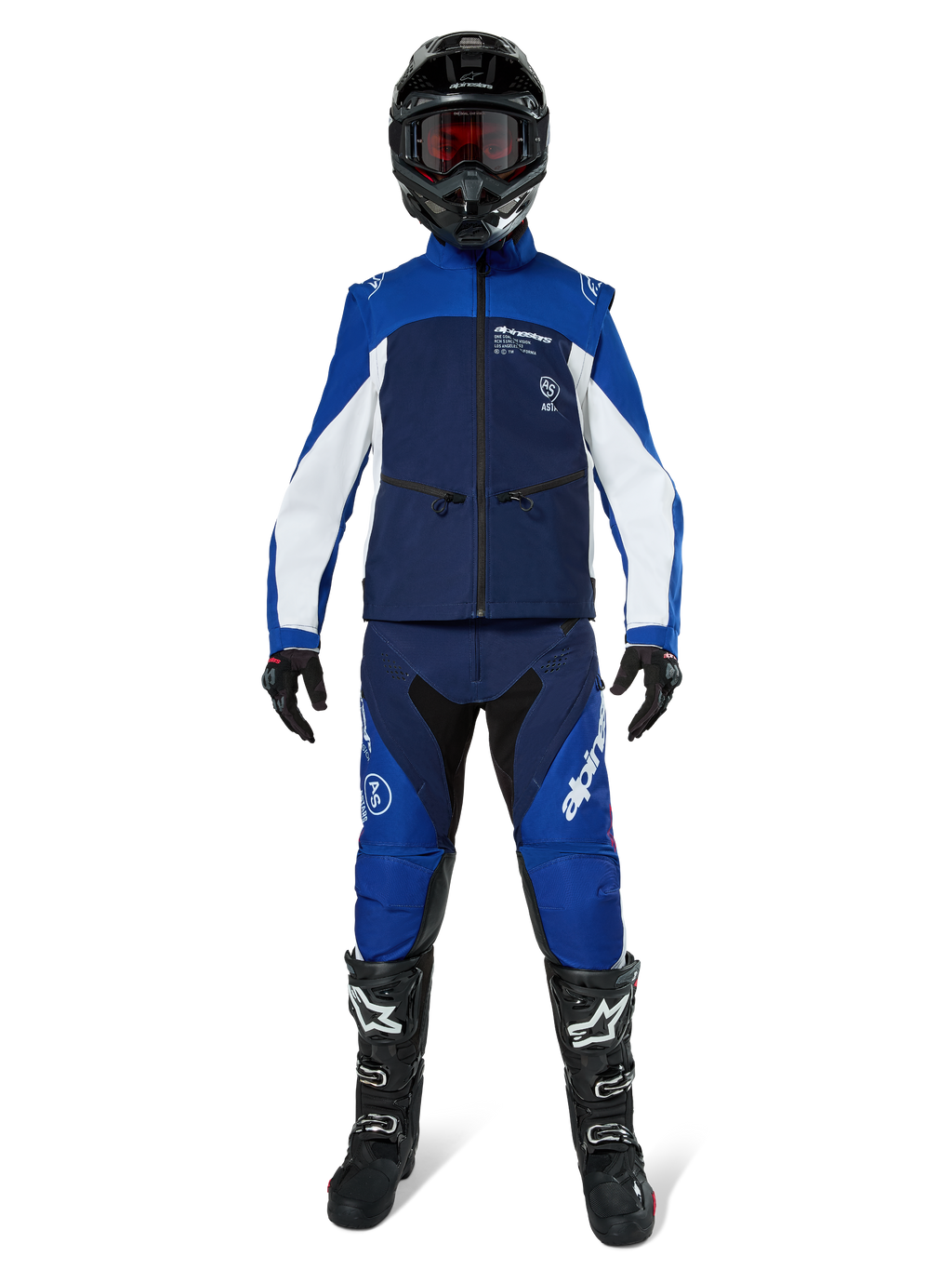 Chaqueta Alpinestars Lite-Dura Softshell, chaqueta de motociclismo off-road en azul marino, azul brillante y blanco, usada con un conjunto de equipamiento completo a juego que incluye casco negro, pantalones de enduro y botas negras, ropa técnica cortavientos para la conducción de motos de cross