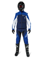 Chaqueta Alpinestars Lite-Dura Softshell, chaqueta de motociclismo off-road en azul marino, azul brillante y blanco, usada con un conjunto de equipamiento completo a juego que incluye casco negro, pantalones de enduro y botas negras, ropa técnica cortavientos para la conducción de motos de cross