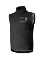 Alpinestars Techstar Softshell Vest, chaleco de motocross negro sin mangas, cuello alto con cremallera frontal, con el logotipo de la estrella roja y marca "ASTARS" y "ONE GOAL. ONE VISION." en el pecho, tejido softshell ligero y cortaviento con forro interior en gris claro, diseñado para conducción off-road