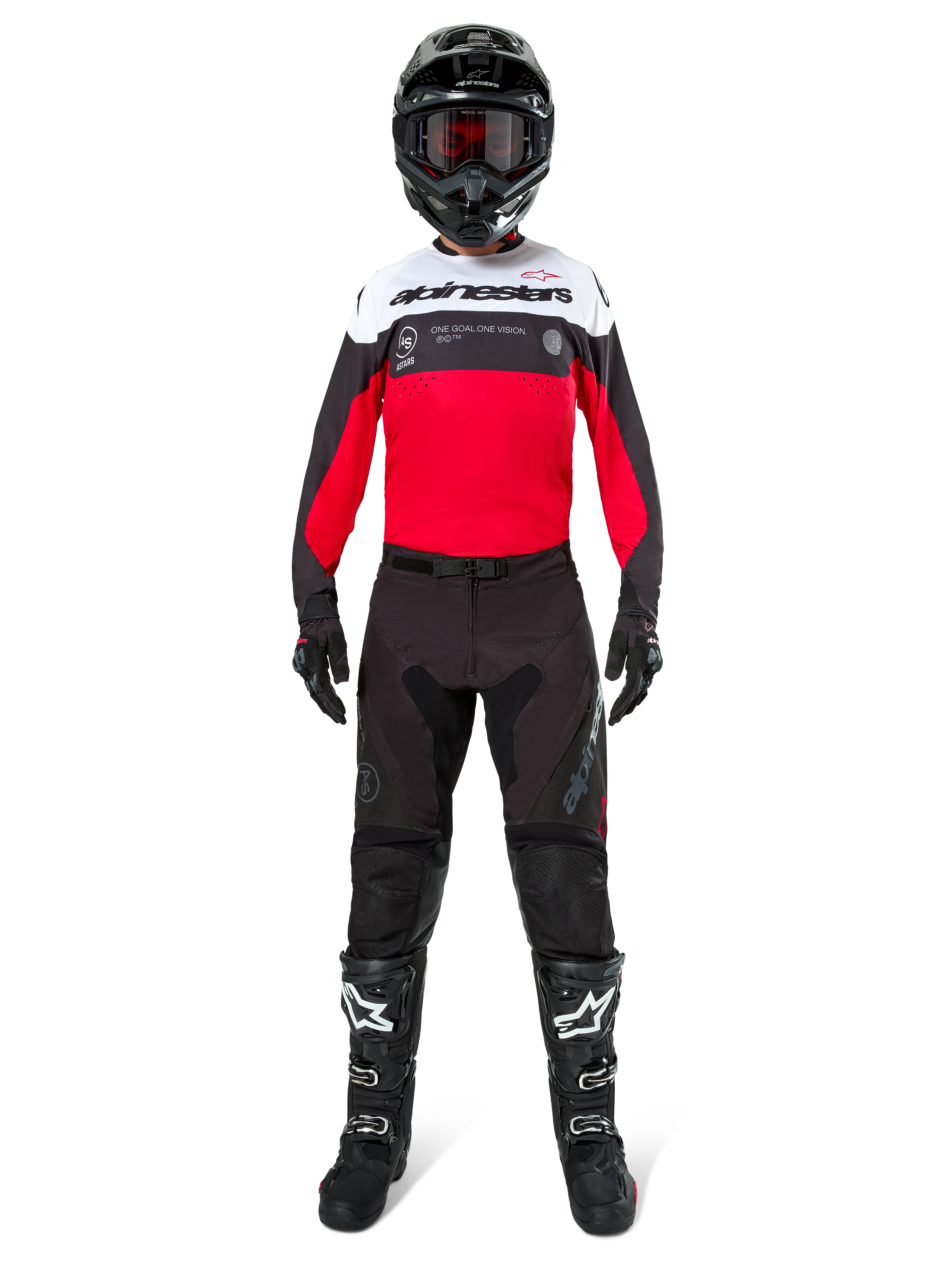Piloto de motocross con pantalones Alpinestars Pro-Dura en color negro y magnet, combinados con un jersey rojo, blanco y negro, casco negro y botas negras, kit completo de equipamiento para carreras off-road, diseño duradero y ligero para conducción de enduro