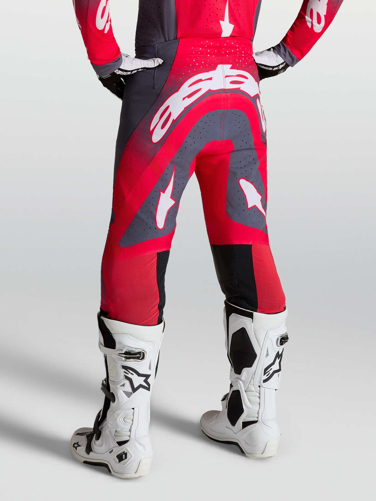 Alpinestars Supertech Hiten AFD Pants, red and graystone motocross pants, on-model rear view with white racing boots.
