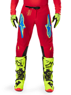 Alpinestars 2025 Supertech Maker Pants, Motocross Pants, Bright Red Yellow Fluo, worn with matching fluo yellow gloves and boots, featuring blue and fluo yellow Astars logos, black inner knee panels, and athletic design for off-road racing