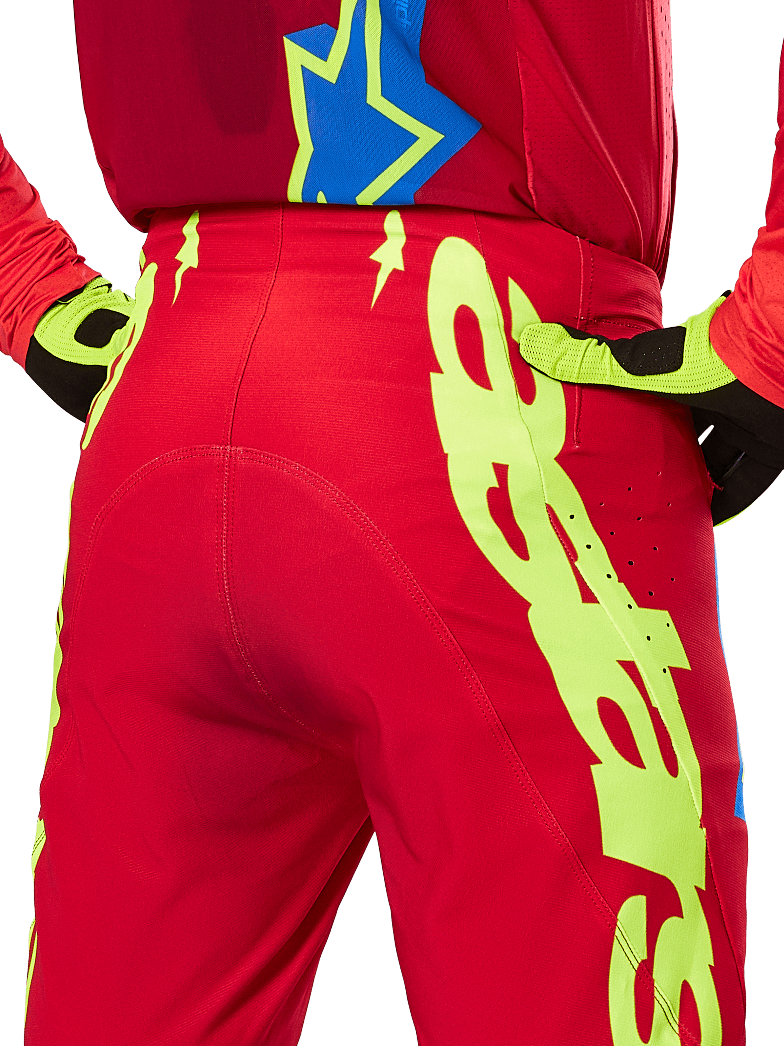 Alpinestars 2025 Supertech Maker Pants, Motocross Pants, Bright Red and Yellow Fluo, rear view featuring large yellow graphics on the legs and matching fluo yellow and black gloves, professional off-road racing gear