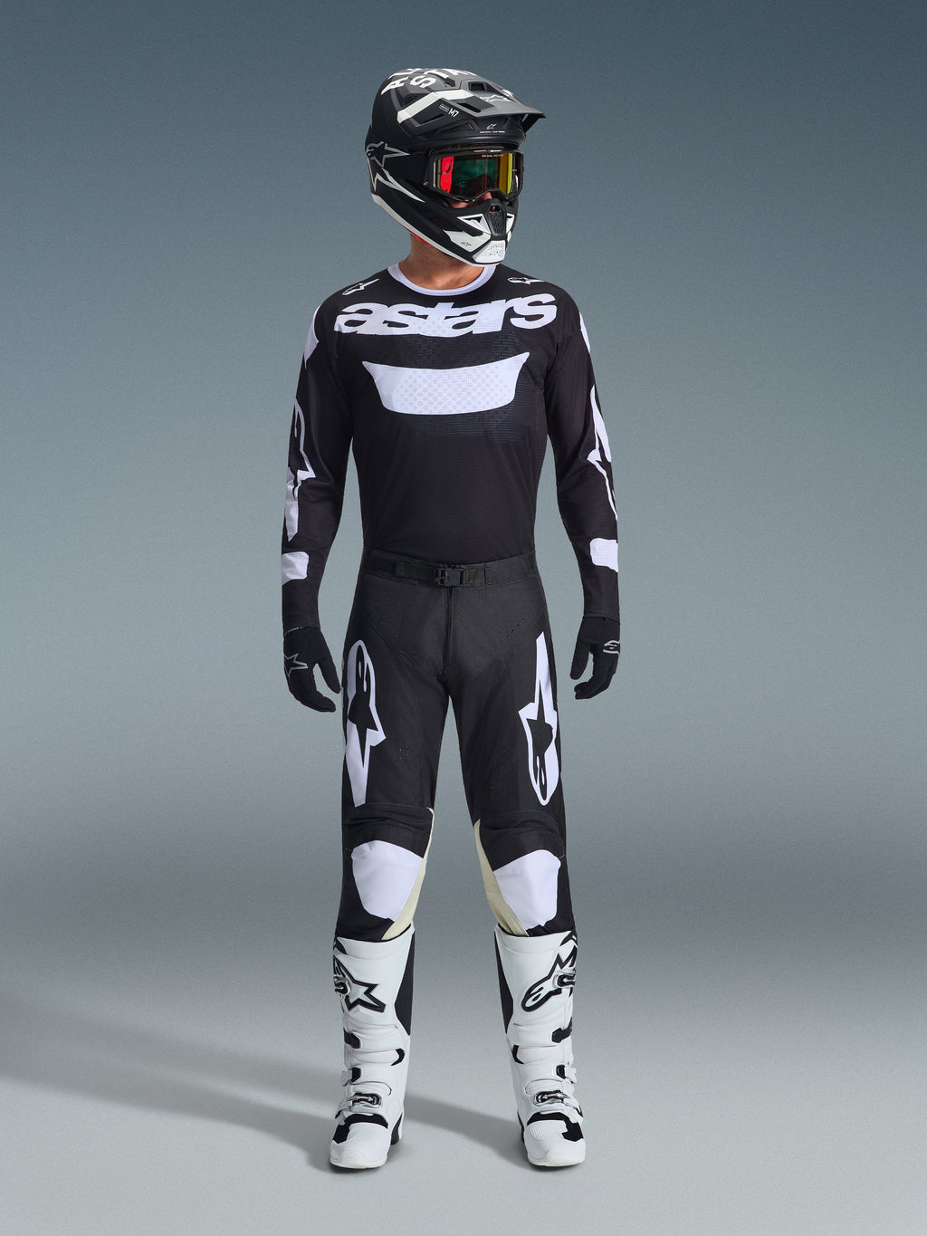 Alpinestars 2026 Racer Air Riway Gear Set, conjunto completo de motocross, negro y blanco, camiseta negra con marca 'astars' blanca, pantalones a juego con paneles blancos en las rodillas, botas blancas con hebillas negras y casco negro con gafas de lente roja, equipo profesional de carreras todoterreno