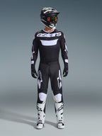 Alpinestars 2026 Racer Air Riway Gear Set, conjunto completo de motocross, negro y blanco, camiseta negra con marca 'astars' blanca, pantalones a juego con paneles blancos en las rodillas, botas blancas con hebillas negras y casco negro con gafas de lente roja, equipo profesional de carreras todoterreno