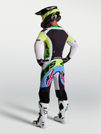 Alpinestars Supertech Dyna, equipo de motocross en verde fluo, negro y lila claro con jersey y pantalones, vista trasera