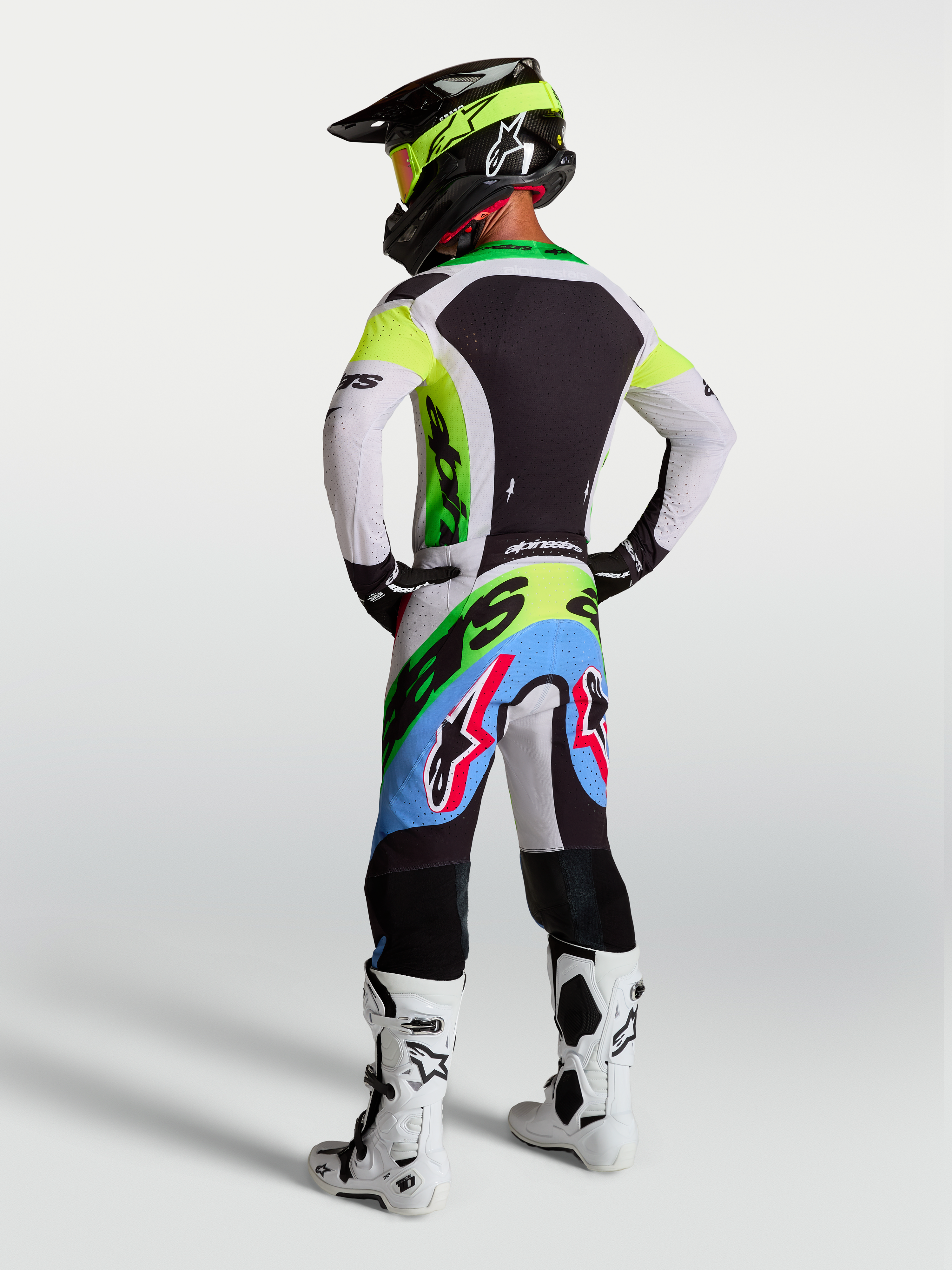 Alpinestars Supertech Dyna, equipo de motocross en verde fluo, negro y lila claro con jersey y pantalones, vista trasera