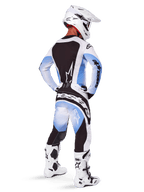 Motocross rider seen from behind wearing Alpinestars 2025 Techstar Melt Pants and jersey, Black Blue and White gradient design, white helmet, white and black boots, full off-road racing kit.