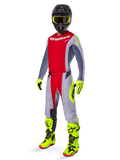 Piloto de motocross con el conjunto Alpinestars 2025 Techstar Melt, jersey y pantalones rojos y grises, guantes y botas amarillo neón vibrante, casco negro, kit completo de competición todoterreno