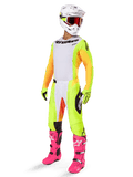 Conjunto de equipo Alpinestars 2025 Techstar Melt, atuendo completo de motocross, jersey blanco con mangas amarillas y naranjas, pantalones amarillo neón, botas rosa brillante, casco blanco con gafas rojas, guantes amarillos, ropa de carreras vibrante y colorida