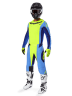 Alpinestars 2025 Techstar Melt Pants, pantalones de motocross, amarillo flúor y azul, usados como parte de un conjunto completo de equipamiento de carreras con jersey a juego, guantes amarillos y negros, botas blancas y negras, y casco negro con gafas blancas, equipamiento coordinado para alto rendimiento en off-road
