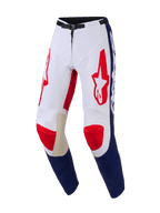 Alpinestars 2026 Racer Riway Pants, pantalones de motocross, blanco, azul y rojo, con logotipos Astar rojos en los muslos, paneles azules en la parte inferior de las piernas, refuerzos interiores de cuero color canela en las rodillas y hebilla magnética negra en la cintura, diseño duradero para rendimiento off-road