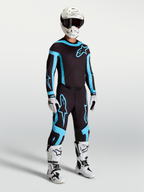 Alpinestars Supertech Vesta Pants, men's black and turquoise motocross racing gear with white boots and helmet.