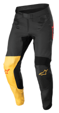 Alpinestars Supertech Blaze Pants, pantalones de motocross, negros, amarillo cálido y rojo flúor, con un panel de rodilla amarillo distintivo, detalles del logo de estrella en rojo, cierre de cintura con trinquete seguro y paneles protectores reforzados para rendimiento todoterreno.