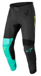 Alpinestars Supertech Blaze Pants, pantalones de motocross, en negro, verde pastel y amarillo flúor, con paneles asimétricos en las piernas, logos de estrella amarillos y turquesas, inserciones de ventilación de malla y cinturón de ajuste de trinquete para carreras off-road