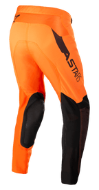 Alpinestars Supertech Blaze Pants, pantalones de motocross, naranja y negro con amarillo flúor, vista trasera de tres cuartos que muestra refuerzos de cuero negro en las rodillas, logotipo ASTARS en el muslo y paneles de malla transpirable, diseñados para conducción profesional en tierra