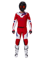 Alpinestars 2025 Racer Veil Pants y conjunto completo de equipamiento de motocross, rojo brillante y blanco con detalles en azul, incluye jersey a juego, casco negro con gafas naranjas, botas blancas y negras, y guantes rojos, look coordinado de alto rendimiento para carreras off-road