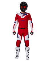 Alpinestars 2025 Racer Veil Pants y conjunto completo de equipamiento de motocross, rojo brillante y blanco con detalles en azul, incluye jersey a juego, casco negro con gafas naranjas, botas blancas y negras, y guantes rojos, look coordinado de alto rendimiento para carreras off-road