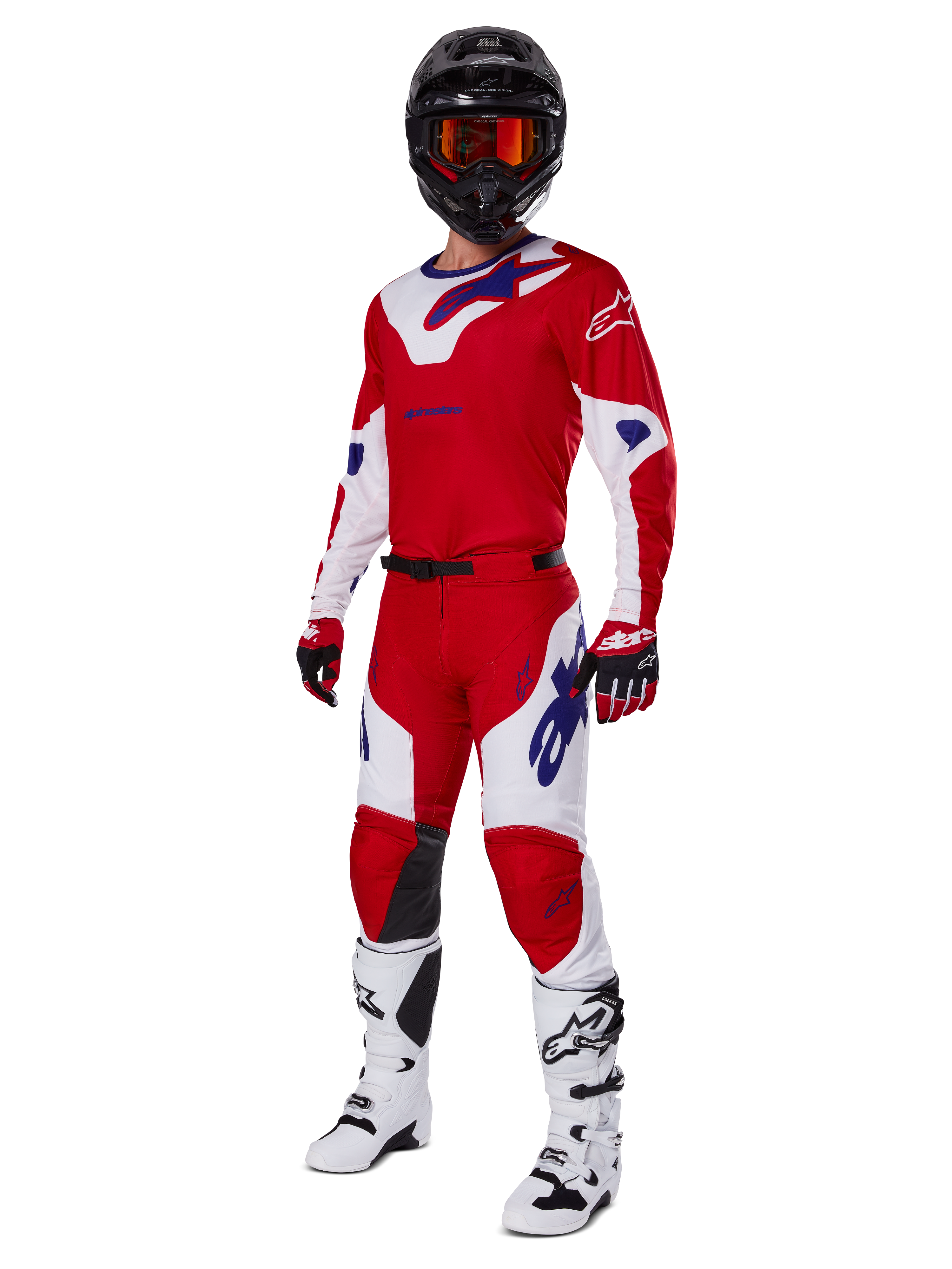 Alpinestars 2025 Racer Veil Pants, pantalones de motocross, rojo brillante y blanco, usados como parte de un conjunto completo de equipamiento de competición que incluye una camiseta roja y blanca a juego, casco negro con gafas naranjas, botas blancas y guantes rojos, con logotipos de Alpinestars en un llamativo color azul.