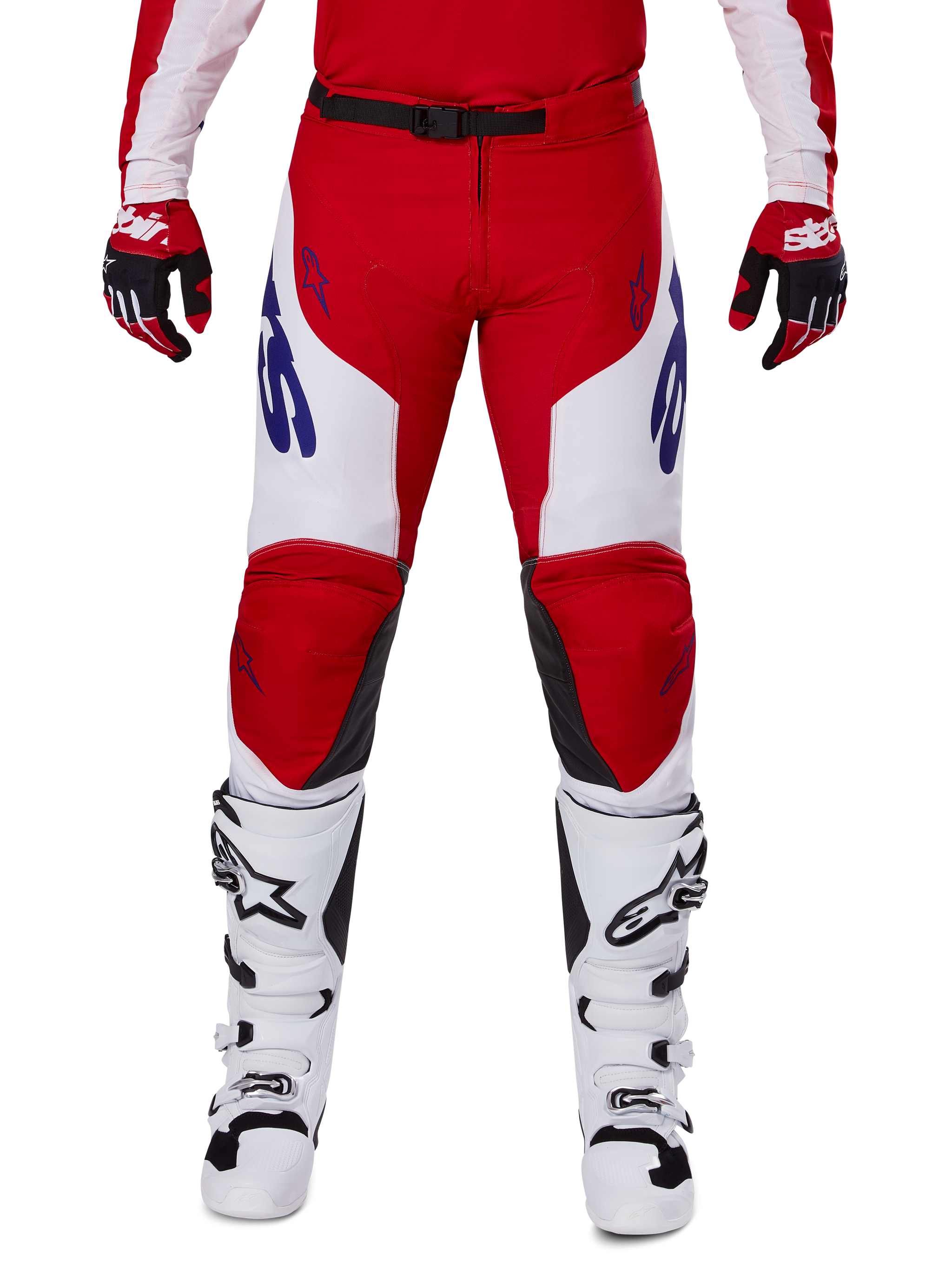 Alpinestars 2025 Racer Veil Pants, pantalones de motocross, rojo brillante y blanco, usados con guantes rojos a juego y botas blancas, con logotipos azules en los muslos y un cinturón negro, corte deportivo ergonómico para una conducción de alto rendimiento