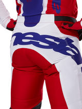 Alpinestars 2025 Racer Veil Pants, pantalones de motocross, rojo brillante y blanco con logotipos azules, detalle de la vista trasera de la zona del asiento con un gran logotipo de Alpinestars, parte de una equipación de competición off-road coordinada