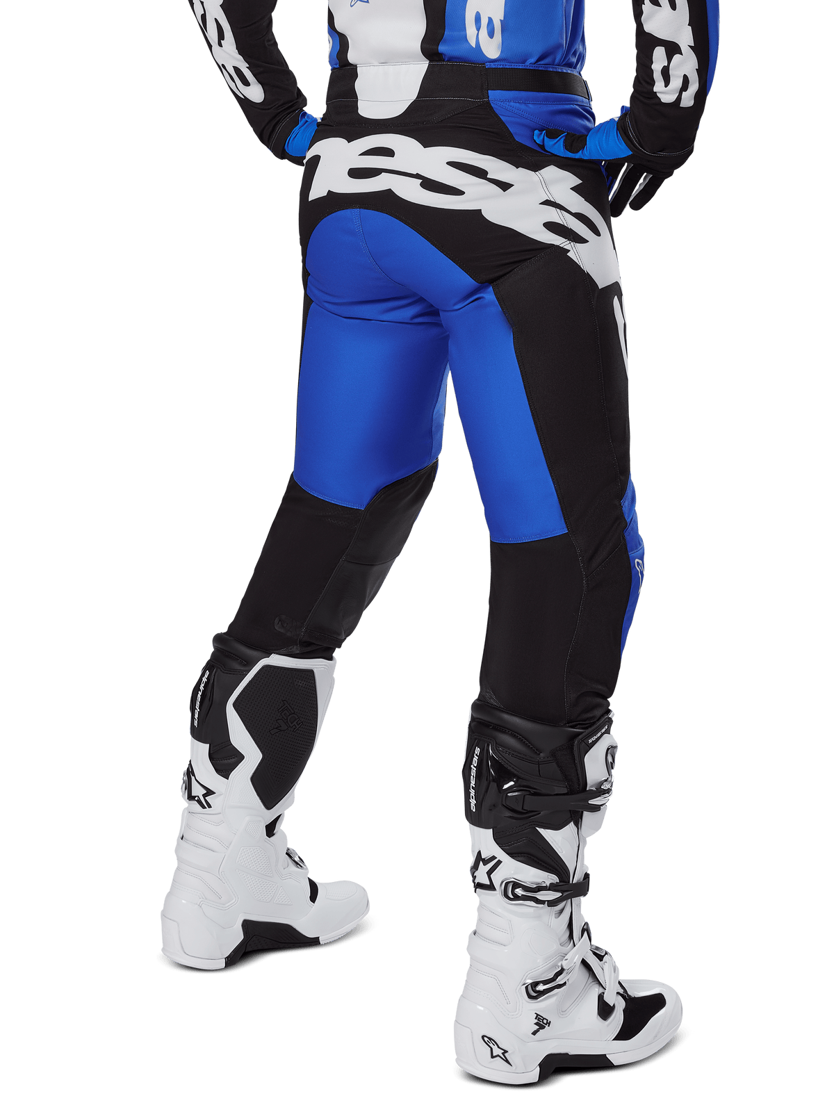 Alpinestars Racer Veil Pants 2025, pantalones de motocross, azul y negro, vista trasera que muestra un gran logotipo blanco en el asiento, usados con jersey a juego y botas blancas, material técnico duradero para conducción todoterreno