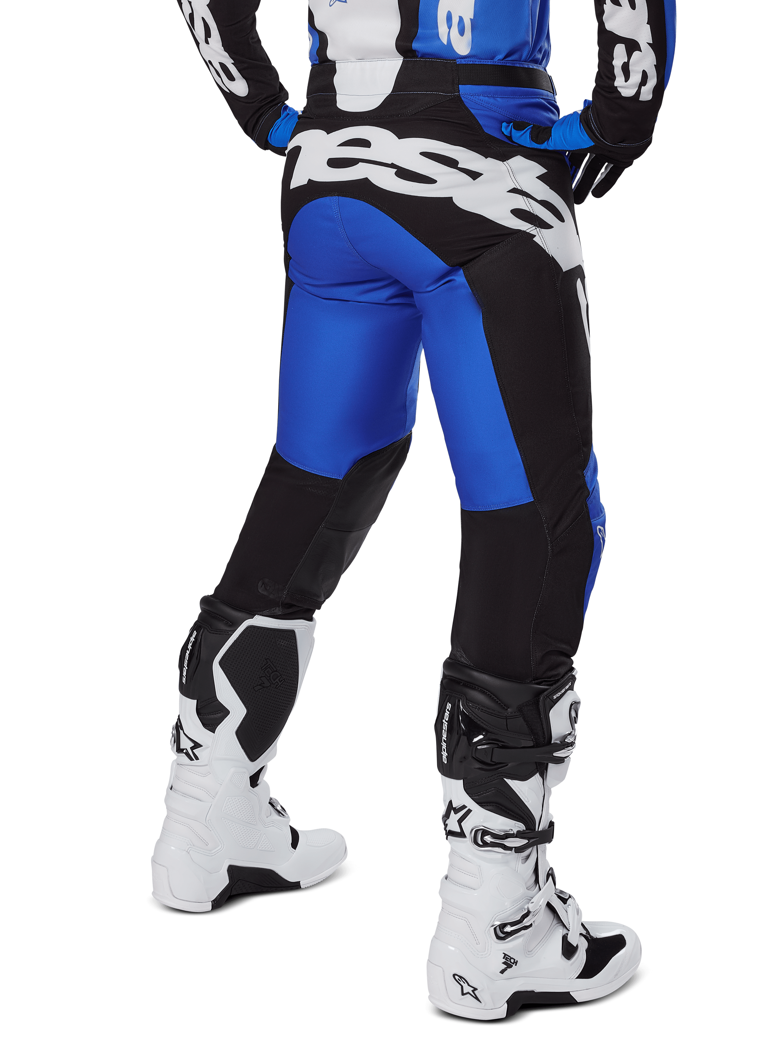 Alpinestars Racer Veil Pants 2025, pantalones de motocross, azul y negro, vista trasera que muestra un gran logotipo blanco en el asiento, usados con jersey a juego y botas blancas, material técnico duradero para conducción todoterreno