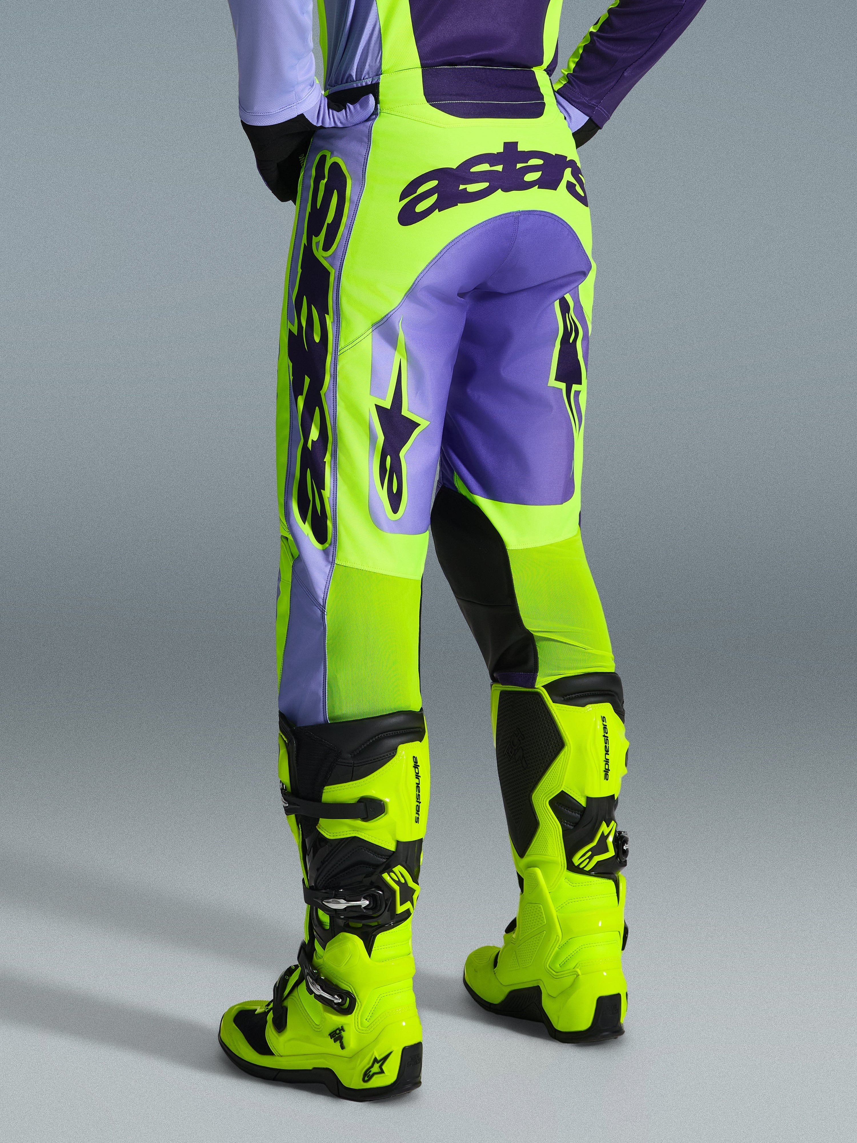 Alpinestars 2026 Racer Portl Pants, pantalones de motocross, púrpura y amarillo flúor, vista trasera con logotipo astars llamativo y detalles en púrpura, usados con botas de motocross amarillo flúor a juego, material sintético duradero para carreras off-road