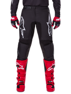 Alpinestars 2025 Fluid Haul Gear Set, Black Motocross Pants with white Astars logos on thighs, paired with vibrant red boots and red and black gloves, coordinated motocross outfit for off-road racing