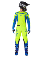 Pantalones Alpinestars Fluid Haul 2025, pantalones de motocross, amarillo fluorescente y azul, usados como un conjunto de equipamiento de competición completo con jersey a juego, botas azules y casco negro, con logotipos azules llamativos en los muslos y paneles negros en las rodillas
