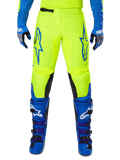 Alpinestars 2025 Fluid Haul Pants, pantalones de motocross, amarillo brillante y azul, usados con guantes y botas a juego, con paneles negros en el interior de la rodilla, logotipos azules llamativos en los muslos y un diseño ergonómico deportivo