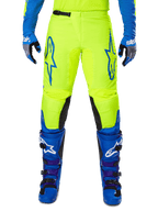 Alpinestars 2025 Fluid Haul Pants, pantalones de motocross, amarillo brillante y azul, usados con guantes y botas a juego, con paneles negros en el interior de la rodilla, logotipos azules llamativos en los muslos y un diseño ergonómico deportivo