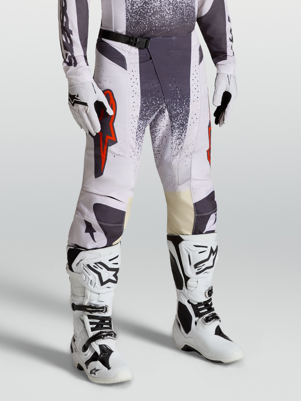 Alpinestars Pantalones Techstar Swan, pantalones de motocross para hombre, lila claro y gris oscuro con detalles en rojo flúor, conjunto con guantes y botas técnicas para competición todoterreno.
