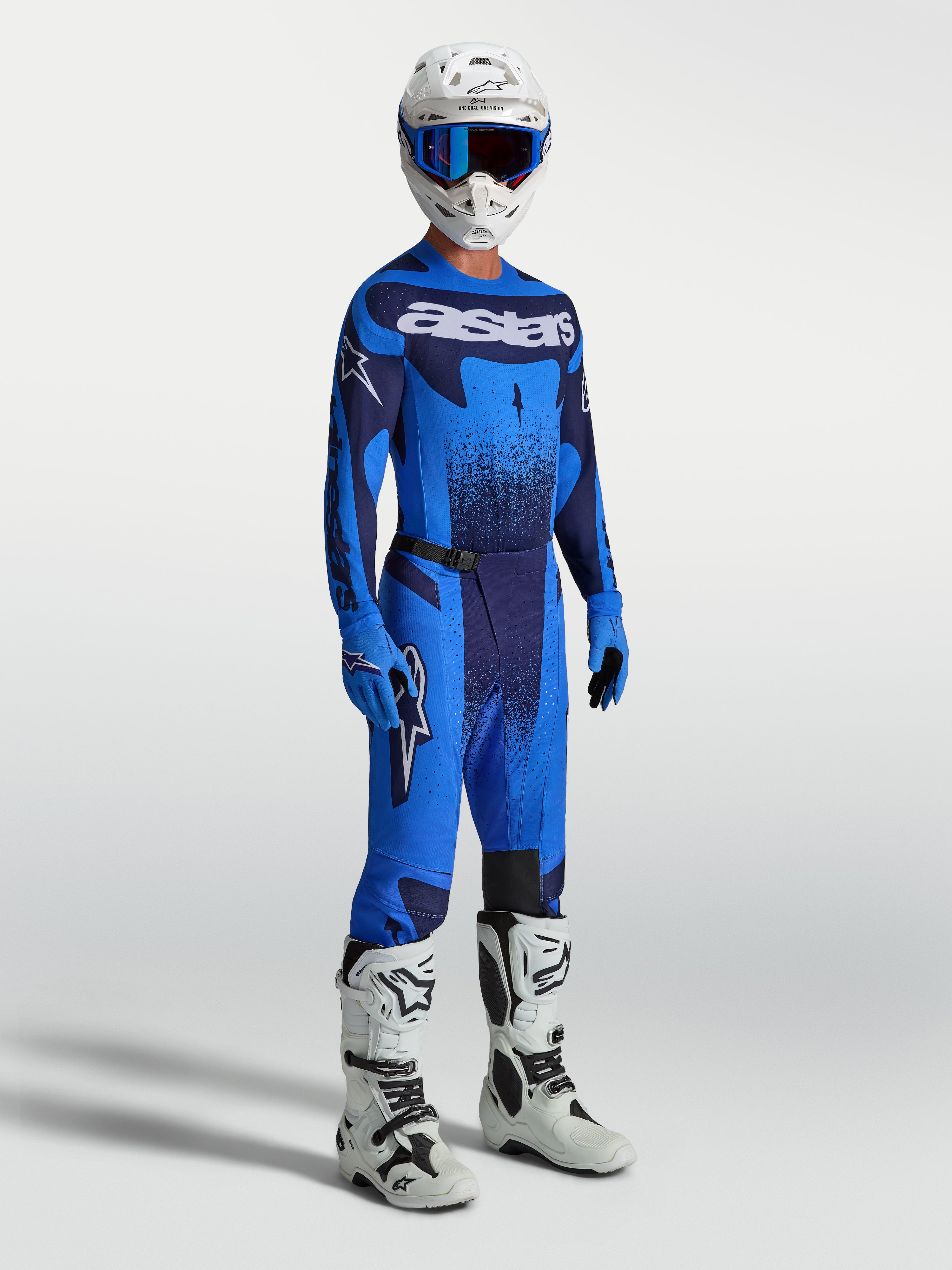 Pantalones Alpinestars Techstar Swan de motocross para hombre, azul y azul marino, con jersey y botas blancas de carreras.