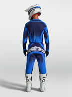Alpinestars pantalones Techstar Swan, equipo de motocross para hombre, azul y azul profundo, vista trasera con botas blancas