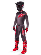 Alpinestars 2025 Supertech Lipan Pants, Motocross Pants, Smoke Bright Red, dark grey base with large red Alpinestars logos on the thighs, worn with matching jersey, black helmet, red and black gloves, and bright red boots, coordinated pro-level motocross outfit