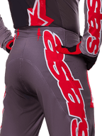 Alpinestars 2025 Supertech Lipan Pants, Motocross Pants, Smoke Bright Red and Gray, close-up of hip and rear showing bold red and white logo graphics, ventilation perforations, and athletic race fit worn with matching gear.