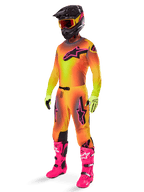 Alpinestars Supertech Lipan Pants 2025, pantalones de motocross, amarillos y rosas, usados como parte de un conjunto completo de equipamiento con jersey degradado a juego, botas rosa brillante, guantes amarillos y casco negro, con logotipos negros llamativos y ajuste atlético para carreras todoterreno