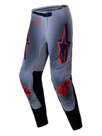 Alpinestars 2025 Supertech Lipan Pants, pantalones de motocross, gris y naranja flúor, con vibrantes logotipos de estrellas en naranja y azul marino en los muslos y las rodillas, paneles internos negros en las piernas y un cinturón ajustable, diseñados para un rendimiento todoterreno de nivel profesional.