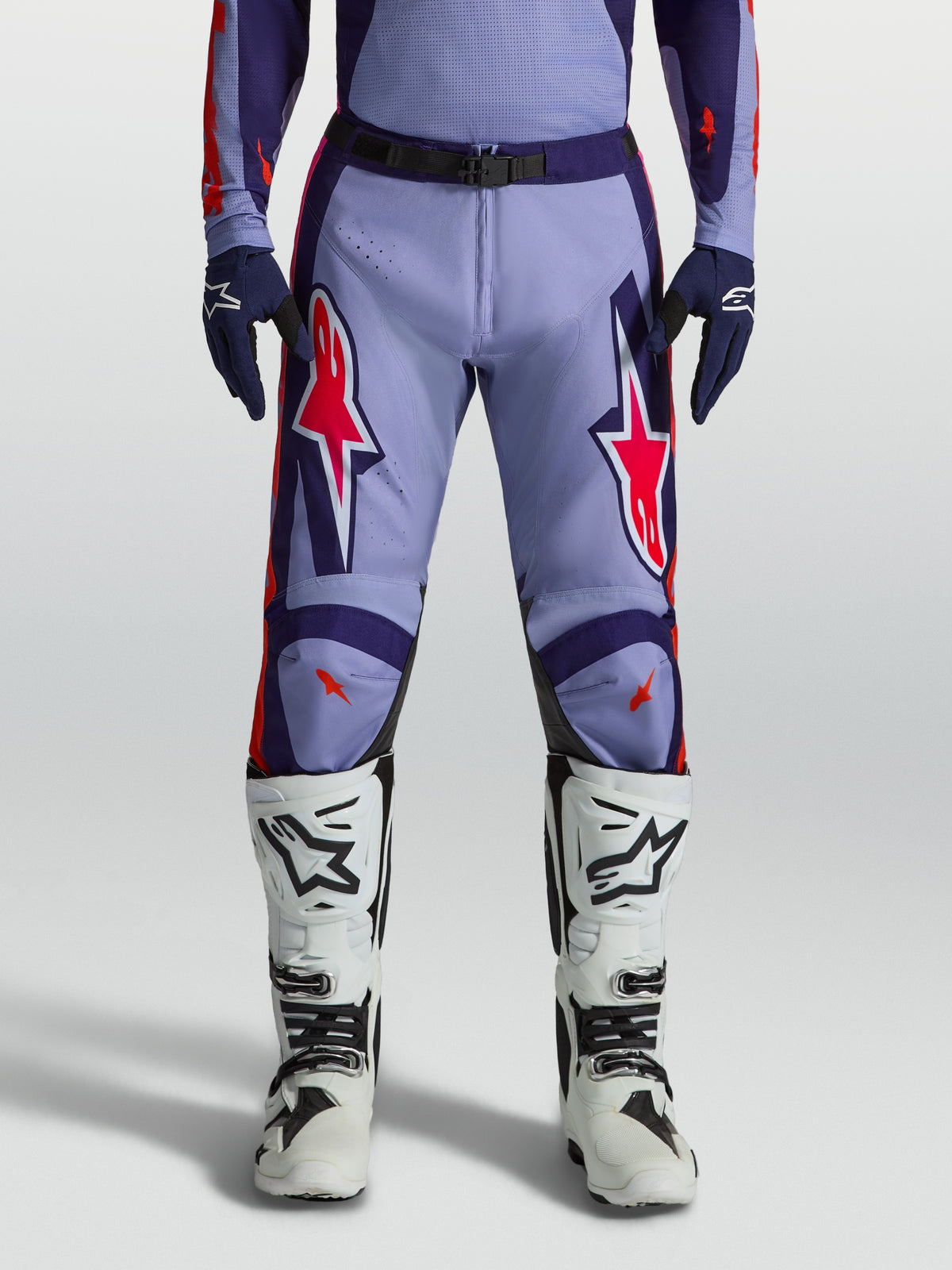 Alpinestars Racer Air Hunt Motocross Pants in light violet and deep purple with pink fluo accents, worn with white boots.