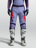 Alpinestars Pantalones Racer Air Hunt para motocross en color violeta y morado con detalles rosa flúor y botas blancas.