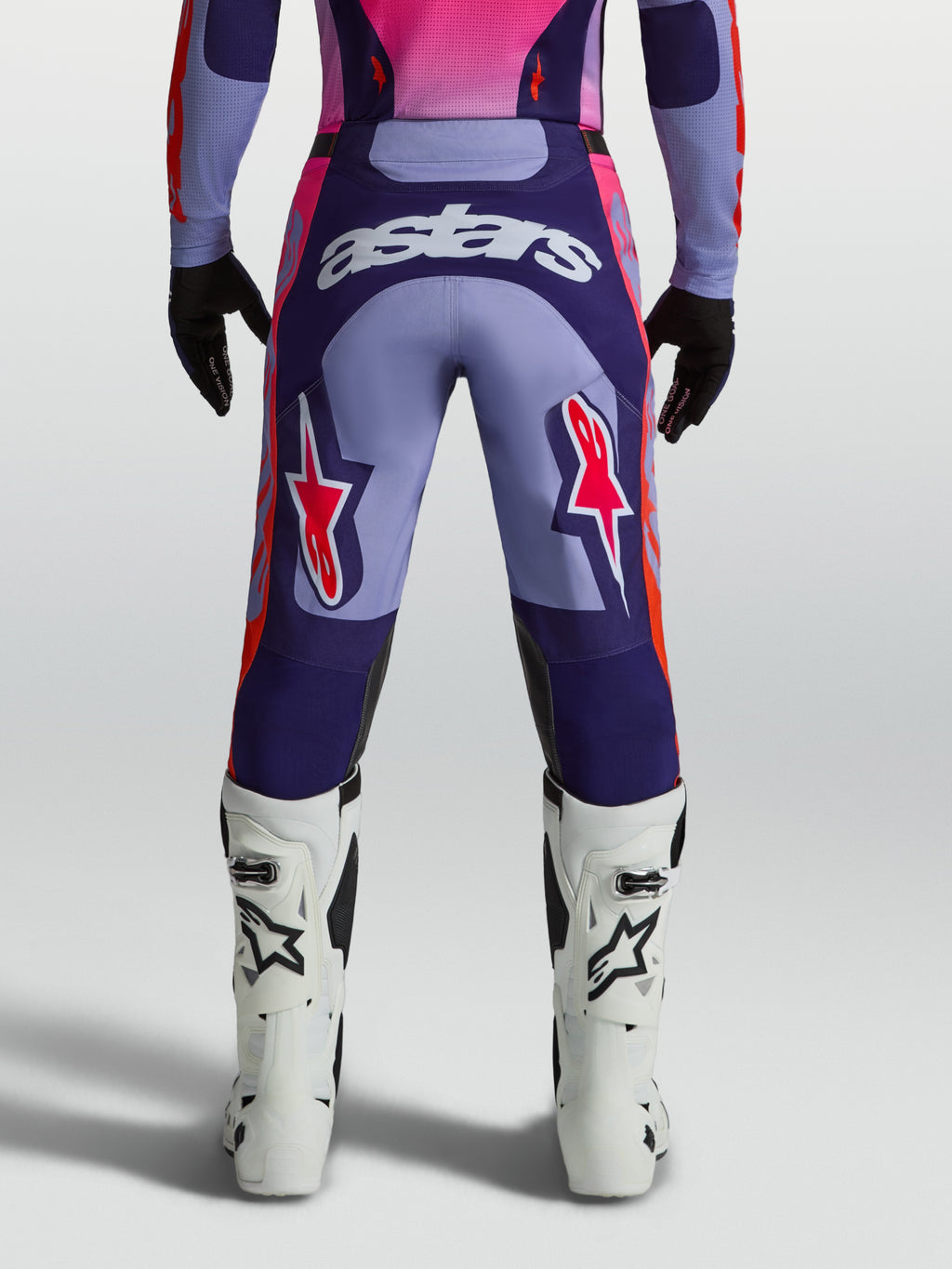 Alpinestars Racer Air Hunt, pantalones de motocross para hombre, morado y rosa flúor, paneles ventilados en vista trasera.