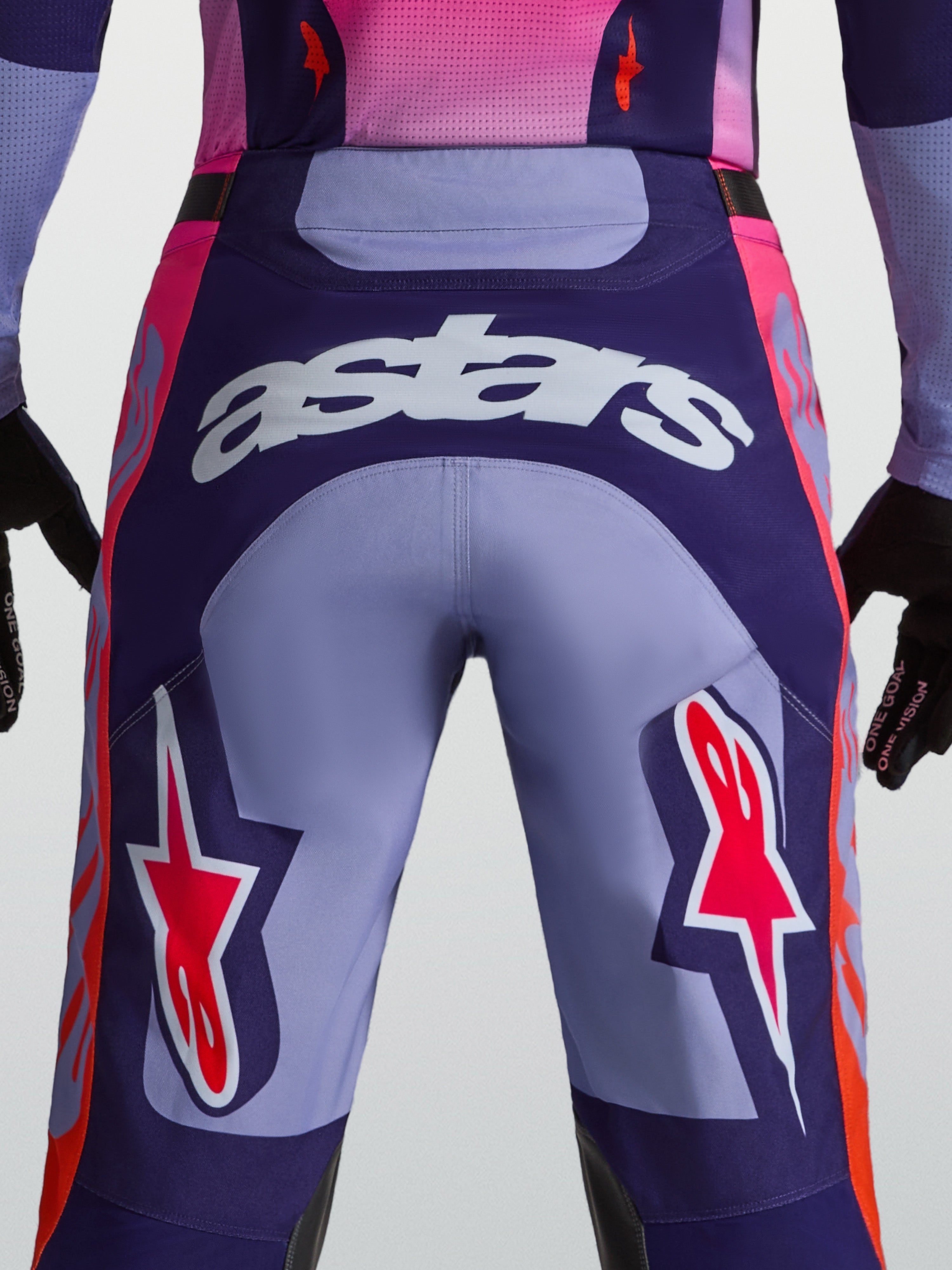 Pantalones Alpinestars Racer Air Hunt para motocross, morados, vista trasera en modelo con logo Astars y paneles ventilados.