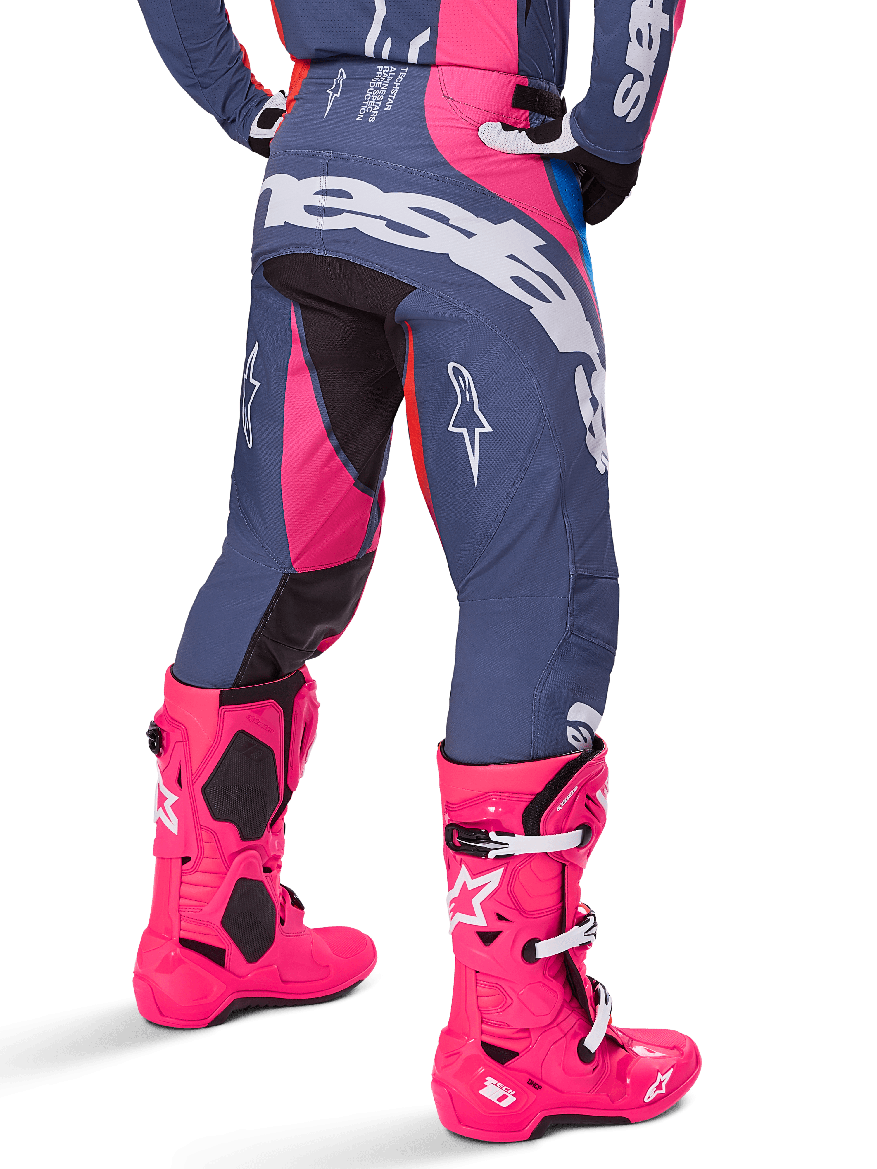 Alpinestars Techstar Dreem Pants 2025, pantalones de motocross, multicolor en gris y rosa, vista trasera con gran logotipo blanco de Alpinestars en el asiento, usados con botas Tech 10 en rosa brillante, equipamiento de carreras todoterreno con paneles reforzados