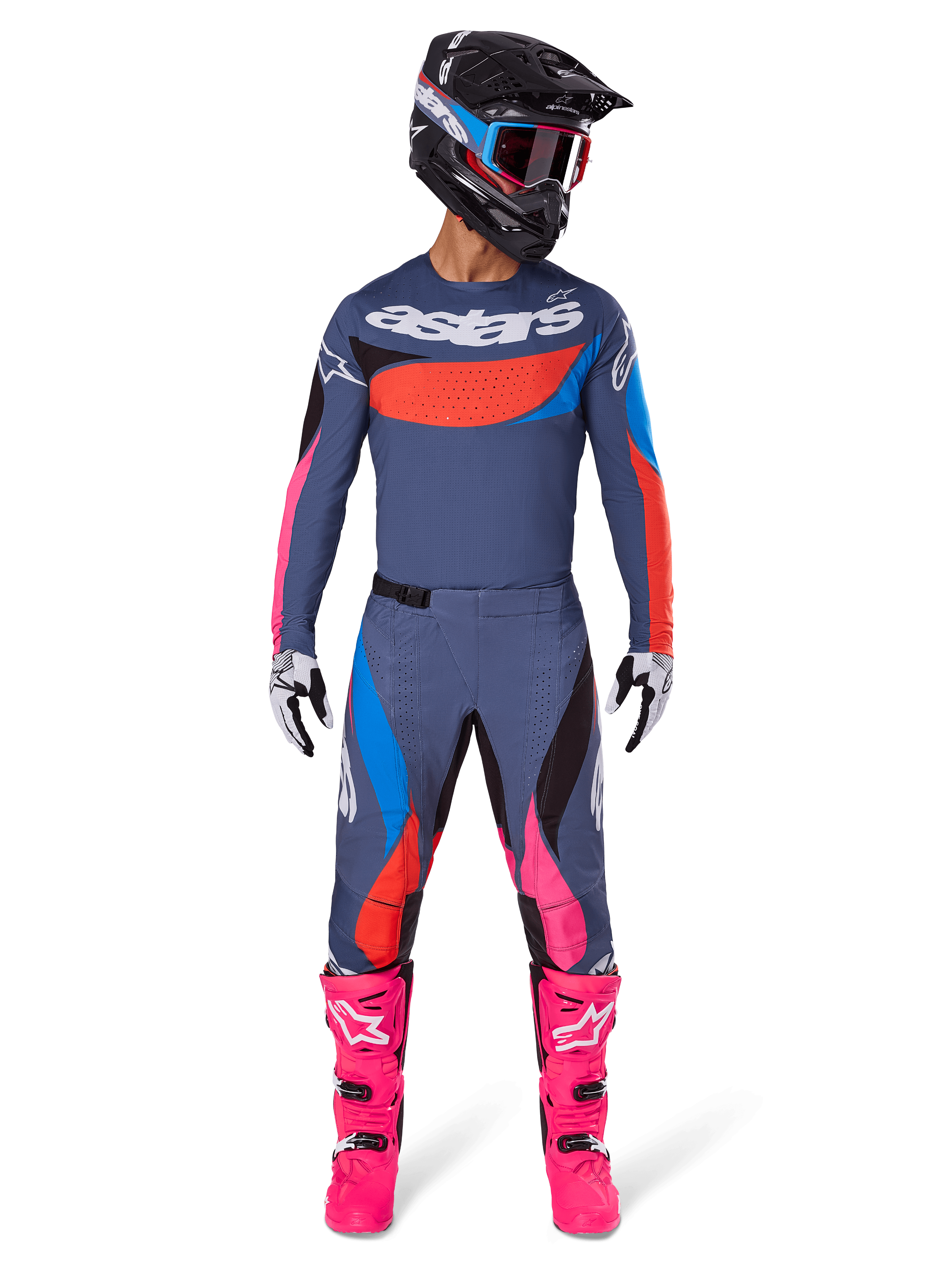 Alpinestars Techstar Dreem Pants 2025, pantalones de motocross gris multicolor con detalles en rosa y azul, usados por un piloto con jersey técnico a juego, casco negro y botas rosa vibrante, equipo completo de alto rendimiento para carreras todoterreno
