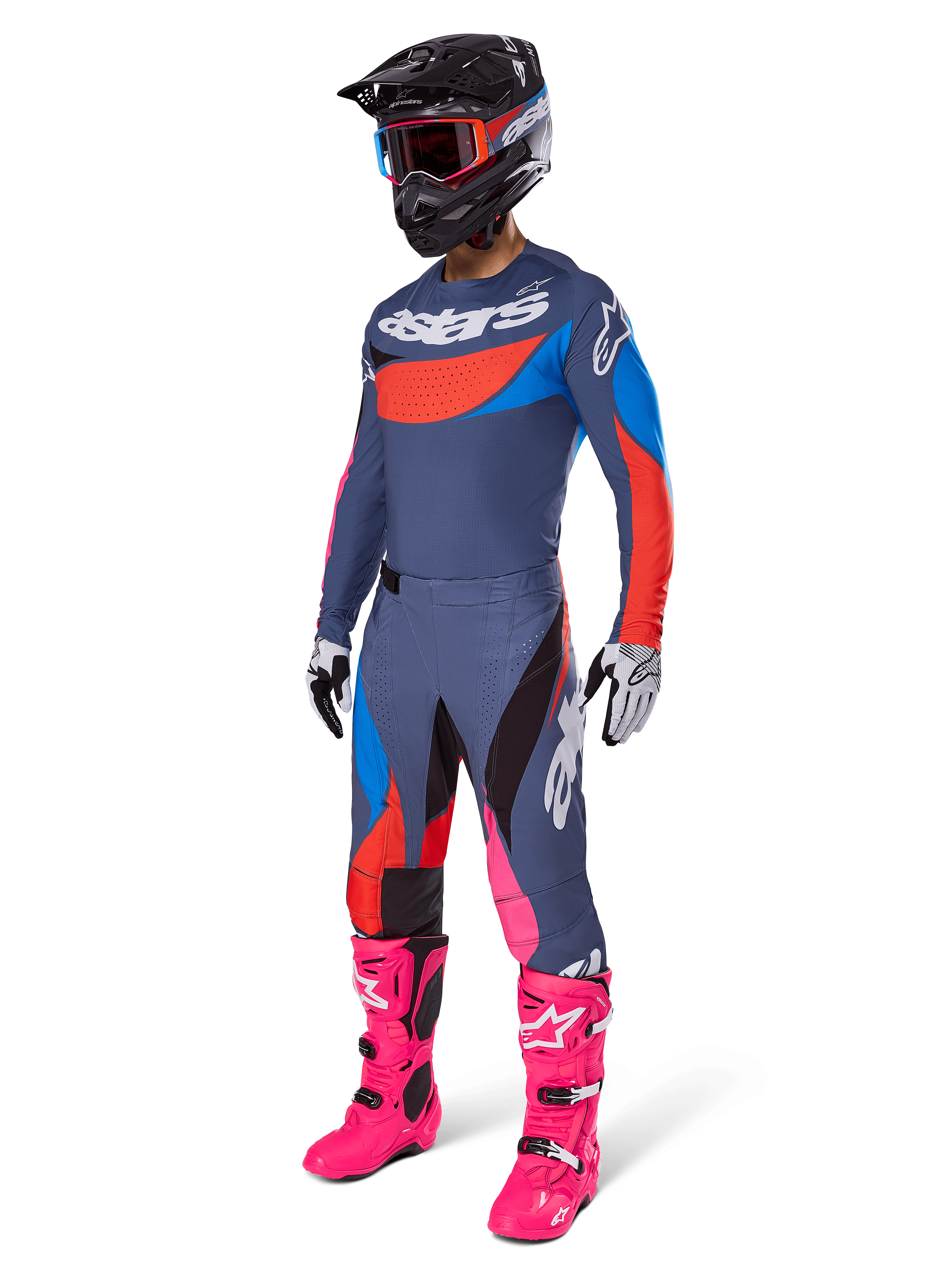 Alpinestars 2025 Techstar Dreem Pants, pantalones de motocross, gris multicolor con detalles en azul, rojo y rosa, usados con jersey a juego y botas rosa brillante, con casco negro y guantes blancos, conjunto completo de equipamiento para carreras todoterreno