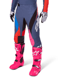 Alpinestars 2025 Techstar Dreem Pants, pantalones de motocross, gris oscuro con paneles azules, rojos y rosas, gráficos blancos, combinados con botas rosa brillante y guantes blancos y negros, diseño audaz de alta visibilidad