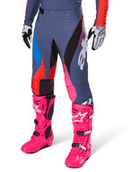 Alpinestars 2025 Techstar Dreem Pants, pantalones de motocross, gris oscuro con paneles azules, rojos y rosas, gráficos blancos, combinados con botas rosa brillante y guantes blancos y negros, diseño audaz de alta visibilidad