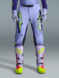 Alpinestars 2026 Supertech Scenz Pants, Motocross Pants, Purple Yellow Fluo, featuring large neon yellow logos on the thighs, worn with matching purple and yellow motocross boots and gloves, athletic-fit performance design for off-road racing