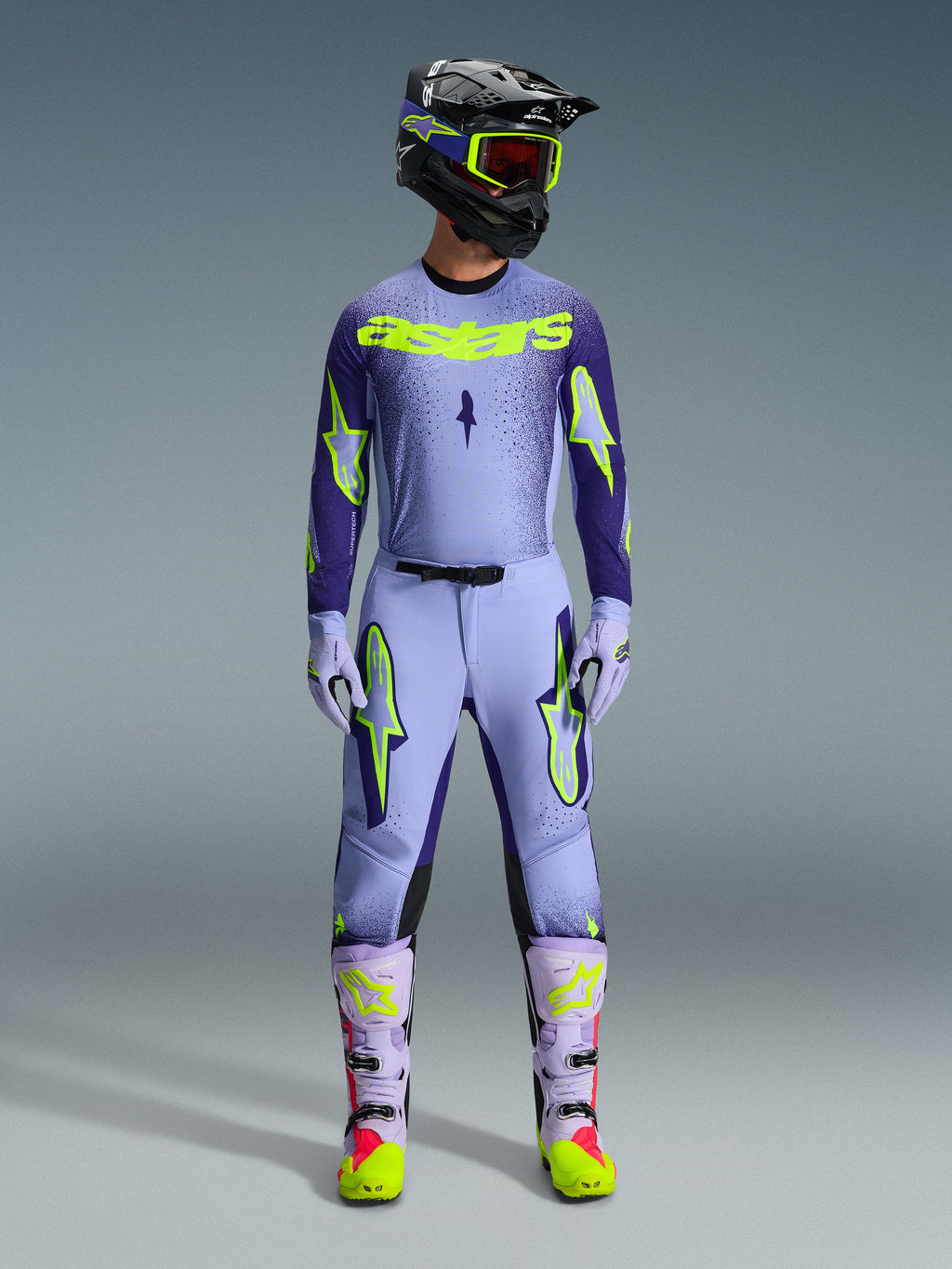 Alpinestars 2026 Supertech Scenz Gear Set, Motocross Racing Outfit, Light Purple and Neon Yellow-Green, full protective gear including black helmet with purple accents, jersey with bold neon yellow branding, matching pants with star graphics, and coordinated boots with pink highlights.